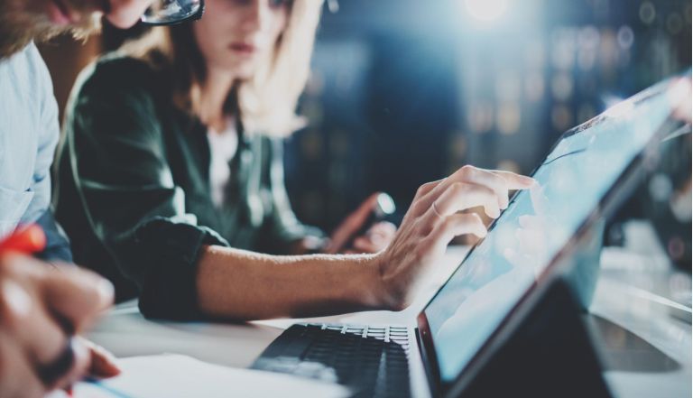 Woman pointing on digital tablet screen at night office .Horizontal.Blurred background.Flares