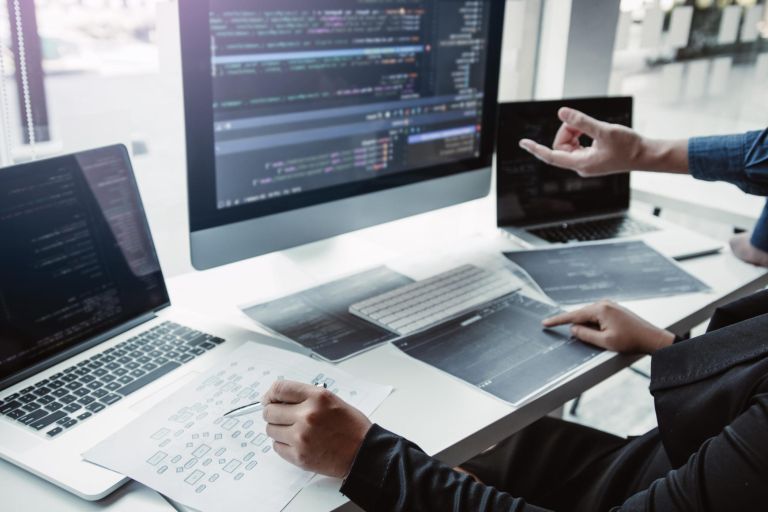 Two asian team working development of programming and encryption technology website design programmers on desk in office.