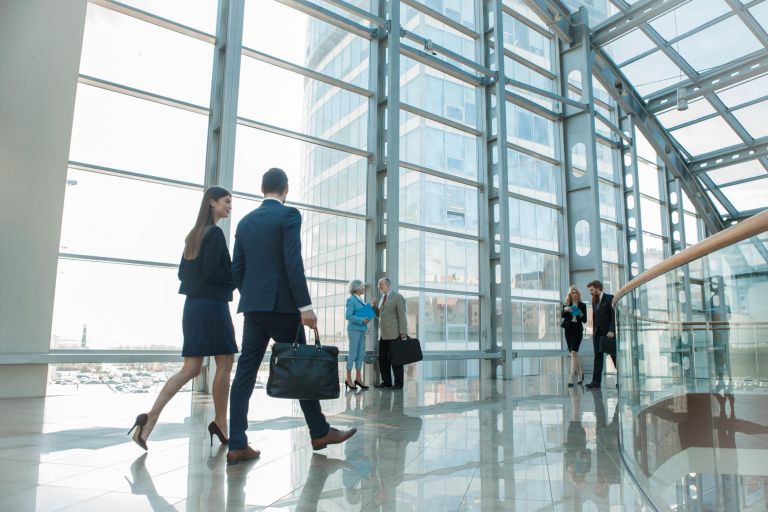 Business people walking in modern glass office building