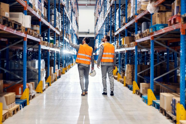 Two businessmen walking around storage.
