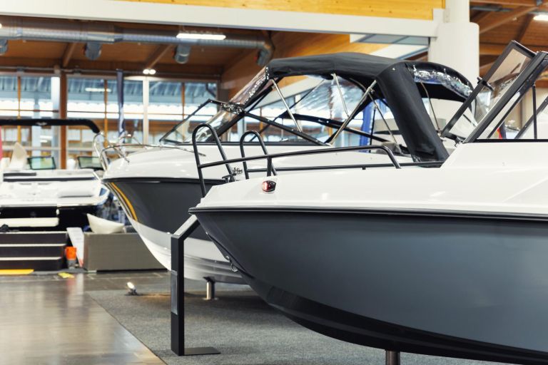 Many small big ship yachts at boat show exhibition indoors hall. Marine fishing yachting sailing vessel expo commercial trading business. Modern recreation sport water transport fair.