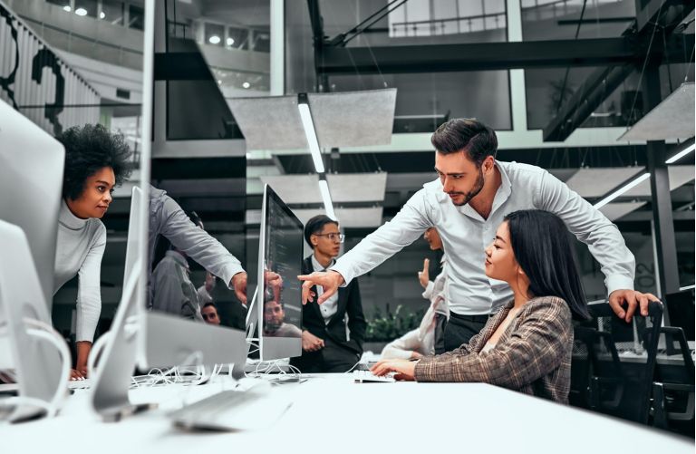 Teamwork. A formally dressed man shows a young woman's work on a computer screen. Business concept, startup, projects, training, IT programming, web design, etc.
