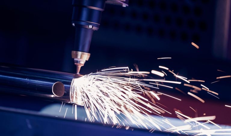 Closeup CNC gas cutting metal sheet, sparks fly. Blue steel color, modern industrial technology