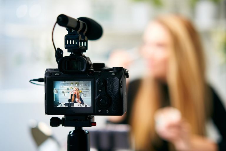 Display of camera recording video blog for blonde beauty blogger woman with makeup at home studio. Influencer vlogger girl live streaming cosmetics masterclass. Online learning, marketing concept.