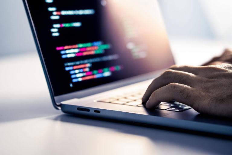 Hacker and malware computer software. Fraud website code in screen. Programmer developing web security with laptop. Data privacy hacking and cybersecurity. Online crime. Criminal hands on keyboard.
